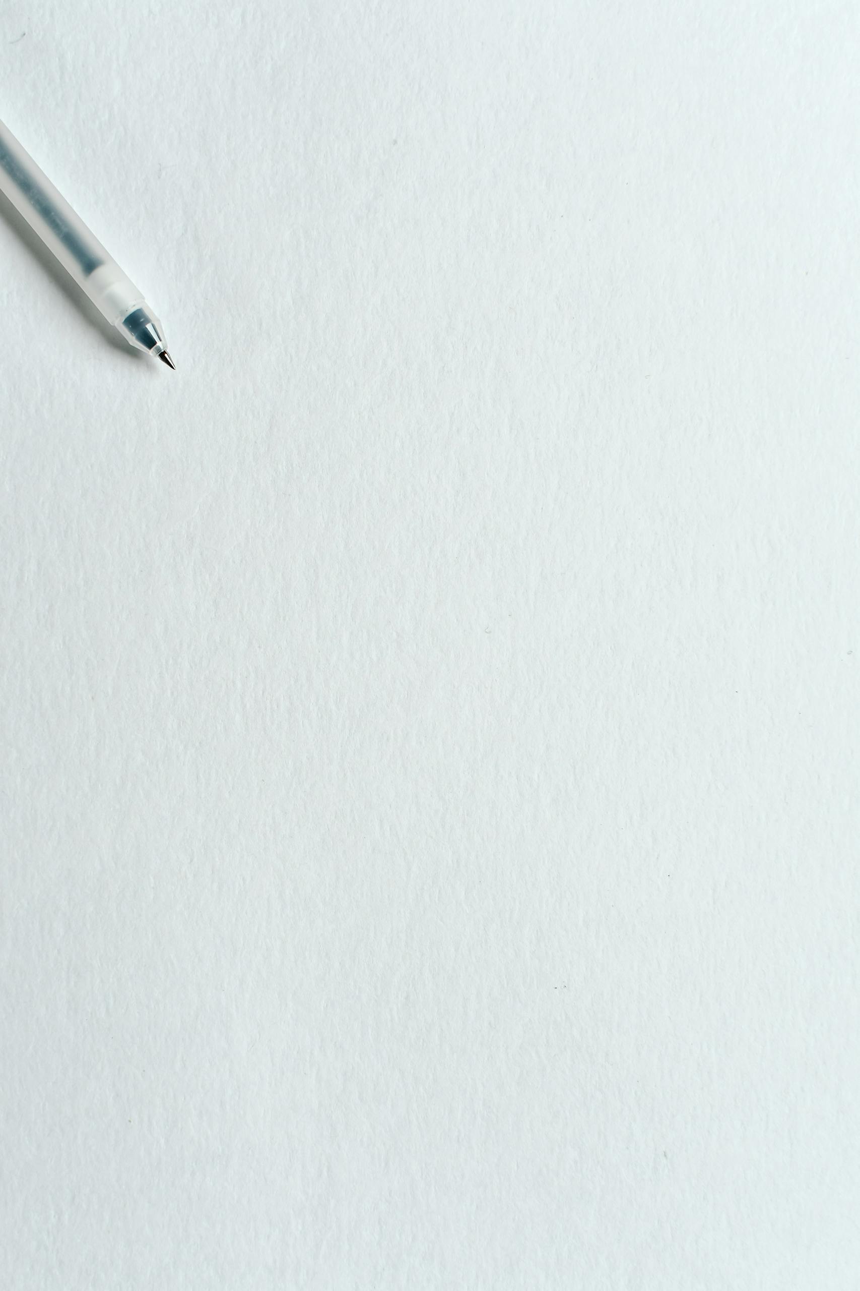 A clean minimalist image featuring a pen on blank paper, ideal for backgrounds or text space.